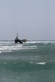 Параллельно земле, то есть воде